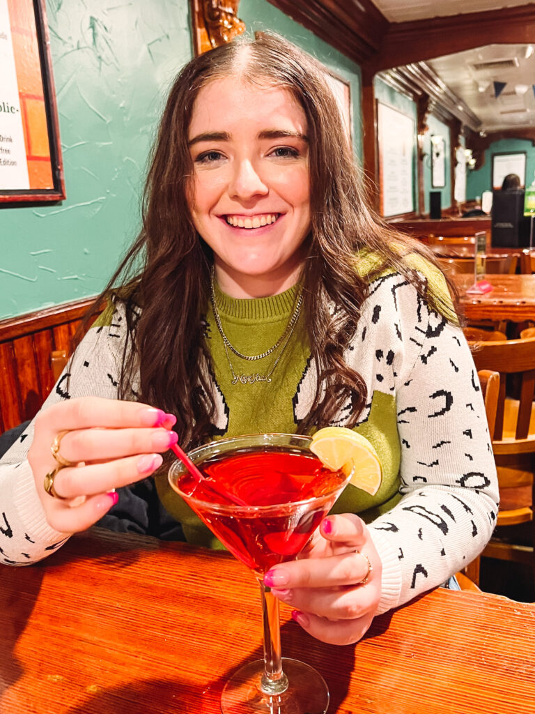 Girl in Irish Pub in NYC with cosmopolitan